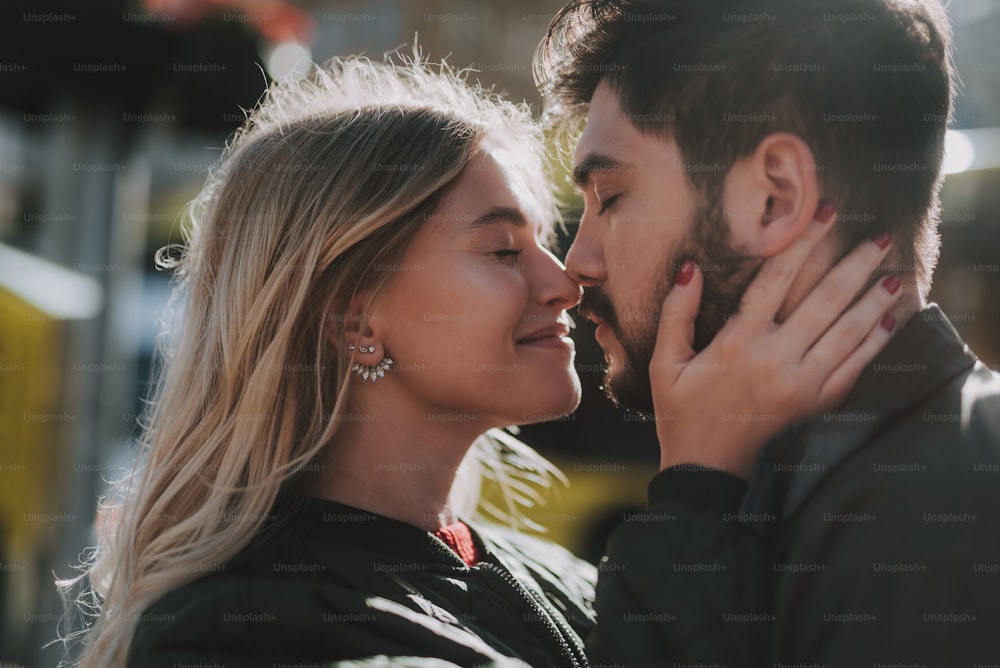 Beautiful love. Close up side view portrait of charming young woman and her boyfriend sharing tender moment while having date