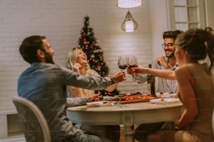 Young friends celebrating Christmas or New Year eve at home