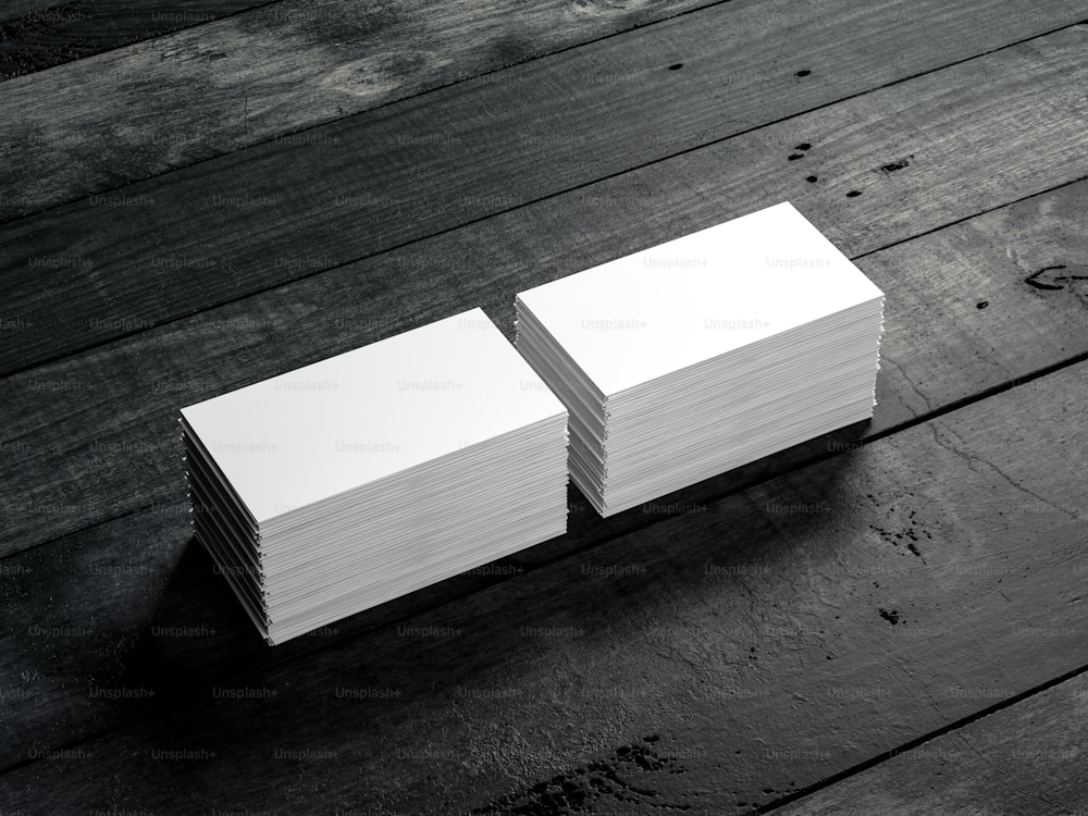 Zwei Stapel weißer Visitenkarten auf schwarzem Holztisch. 3D-Rendering