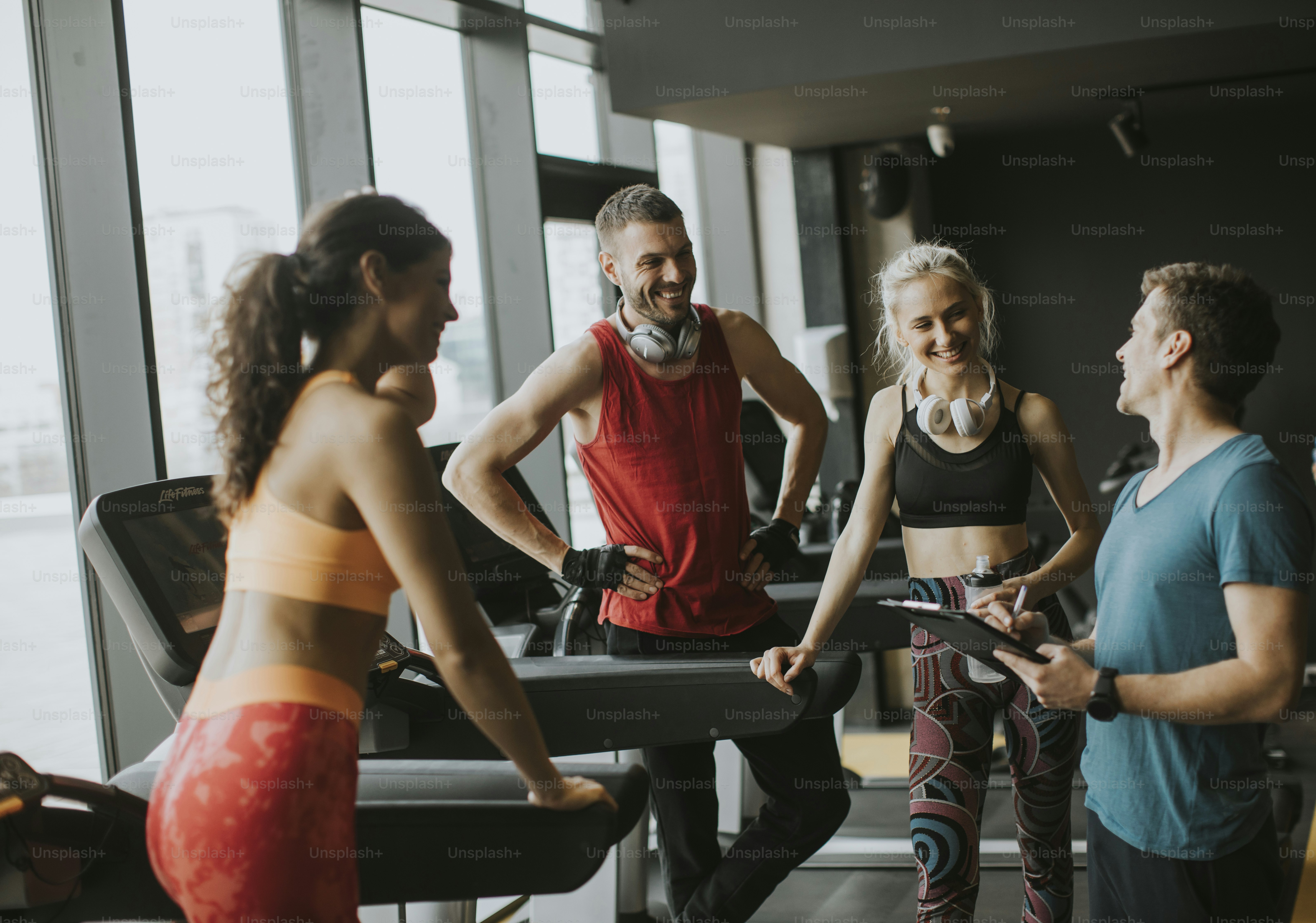 Group of young people in sportswear talking in a gym after a workout
