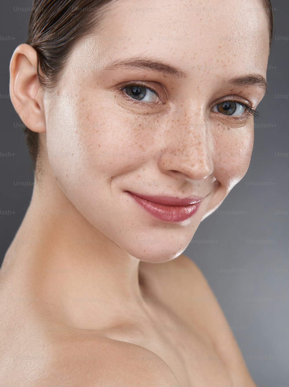 Portrait en gros plan d’une charmante dame au maquillage naturel regardant la caméra avec un sourire mignon