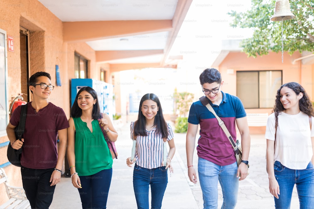 Happy teenager group walking in university campus