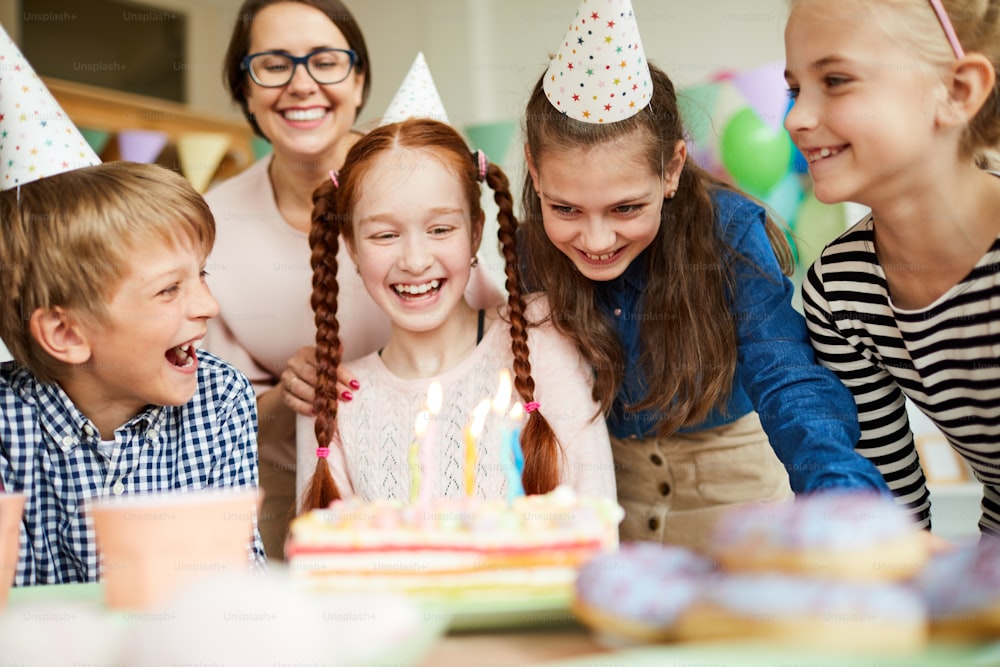 Group of happy children looking at cake during fun Birthday party, copy space