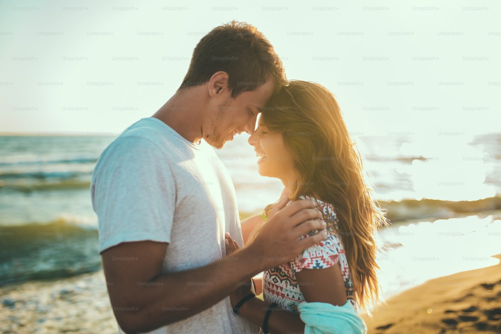 Romantic young couple enjoying summer holidays. Handsome young man with girlfriend on beach.