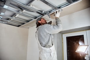 Construction worker plastering gypsum walls inside the house.