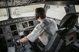 Alter Pilot sitzt in der Kabine Stockfoto. Airways-Konzept