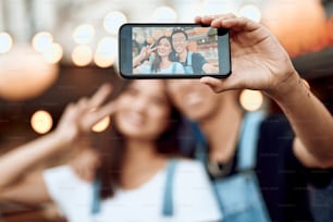 Concept d’amour et de rendez-vous. Écran de téléphone portable avec un jeune homme et une femme asiatiques heureux et bien-aimés faisant un selfie sur la vue de la ville