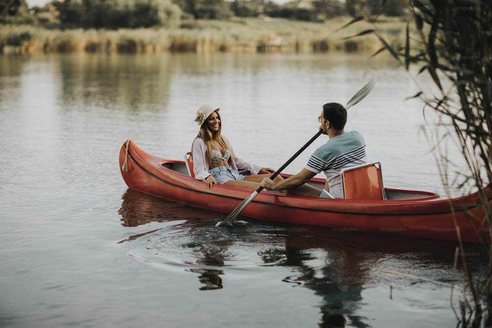 Casal amoroso remando no lago no dia de verão