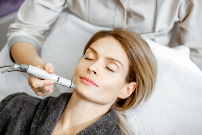 Appareil de peeling ultrasonique utilisé sur la joue en cabine