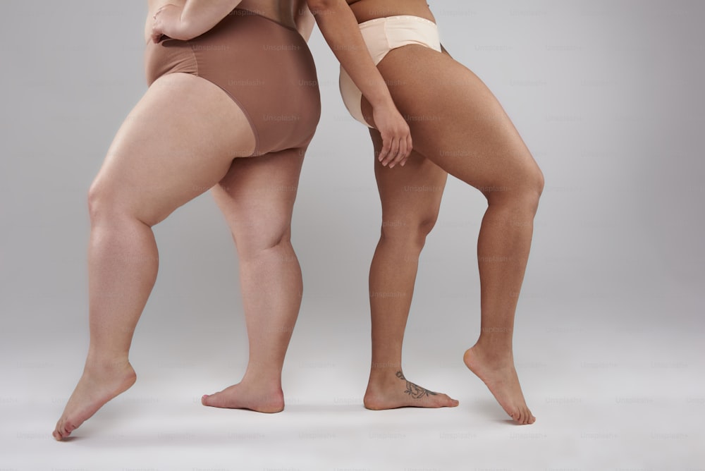 Foto cortada de mulher caucasiana e mulher afro-americana demonstrando suas nádegas