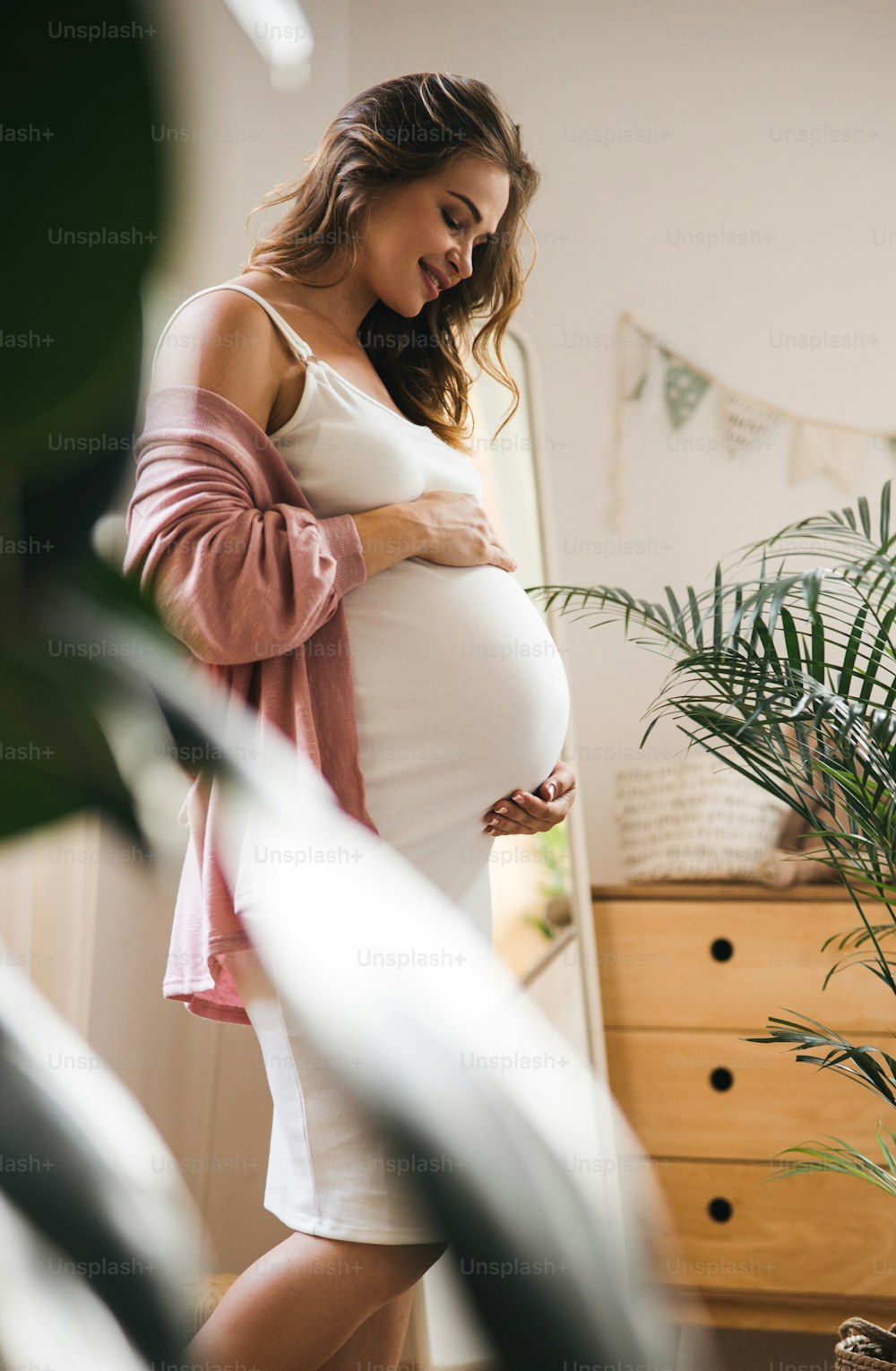 Happy expectant mother touching her tummy stock photo
