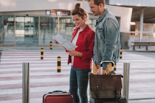 Charming lady holding map and planning the route with her boyfriend