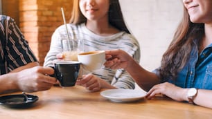 Imagen en primer plano de personas tintineando y tomando café juntas en un café