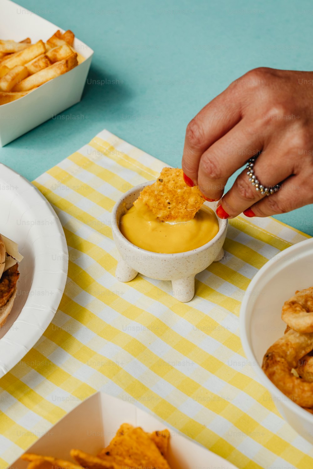 a person dipping some food into a bowl