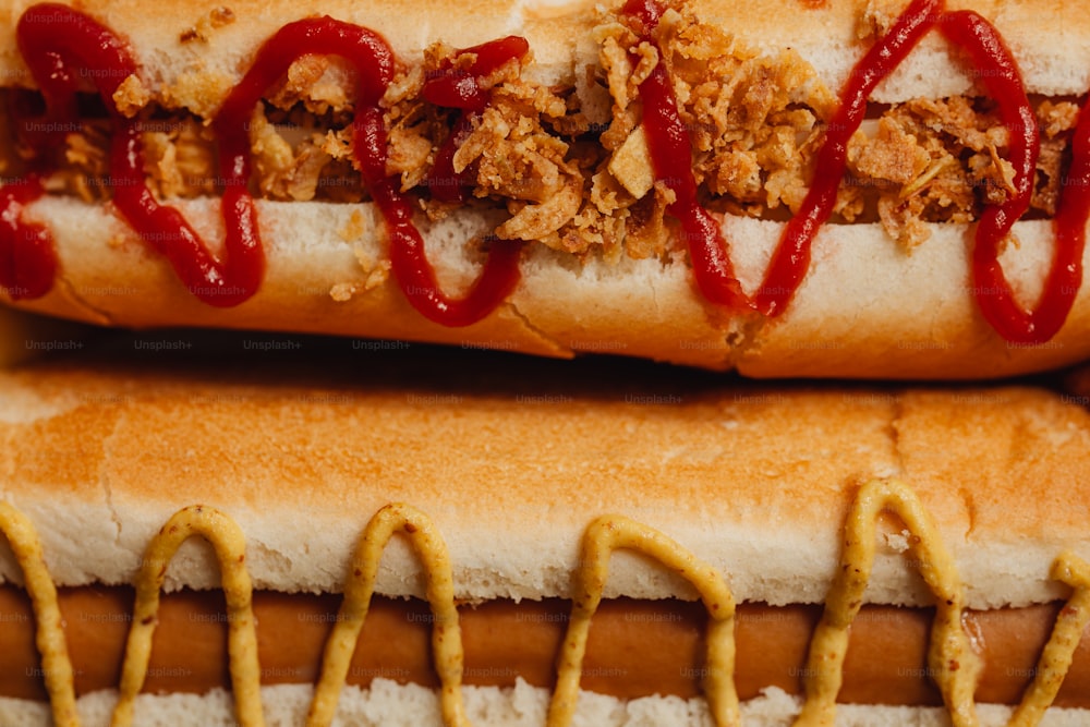a close up of two hot dogs with ketchup