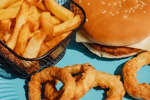 a hamburger and some onion rings on a blue plate
