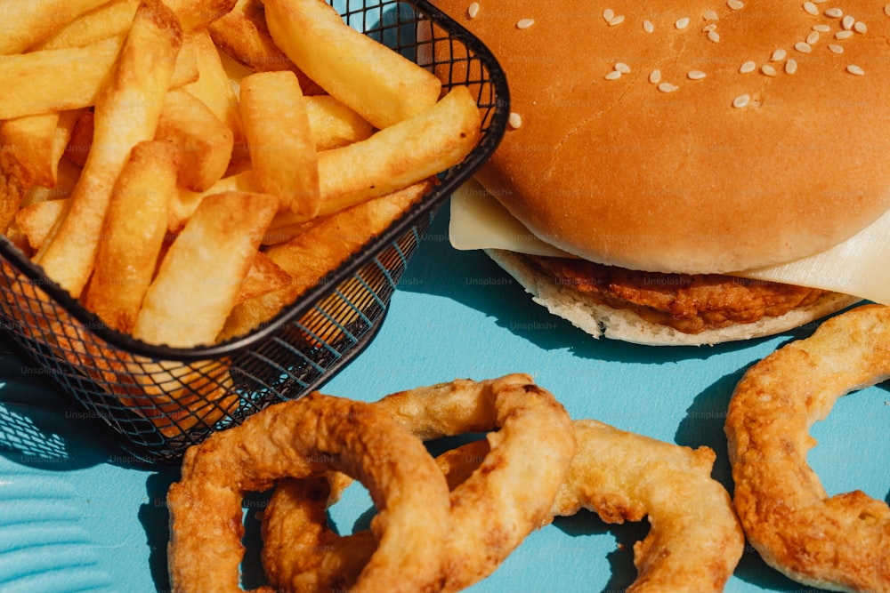 a hamburger and some onion rings on a blue plate