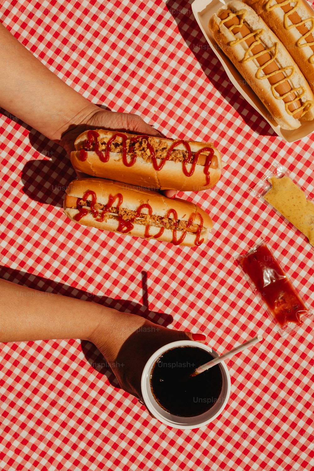 uma mesa coberta com cachorros-quentes cobertos de ketchup