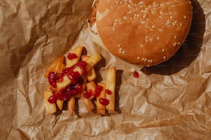 una hamburguesa y papas fritas en un trozo de papel encerado