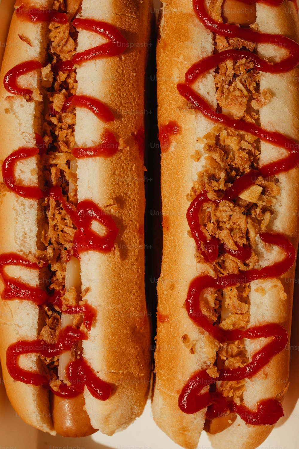 Deux hot-dogs avec ketchup et moutarde dans une boîte