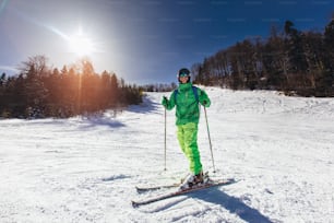 Joven atleta esquiador de estilo libre divirtiéndose mientras corre cuesta abajo en un hermoso paisaje en un día soleado durante la temporada de invierno
