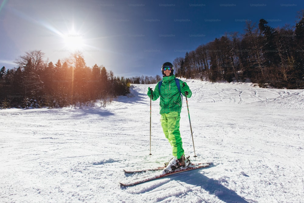 Young athlete freestyle Skier having fun while running downhill in beautiful landscape on sunny day during winter season