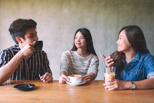 Closeup image of friends enjoyed talking and drinking coffee together in cafe