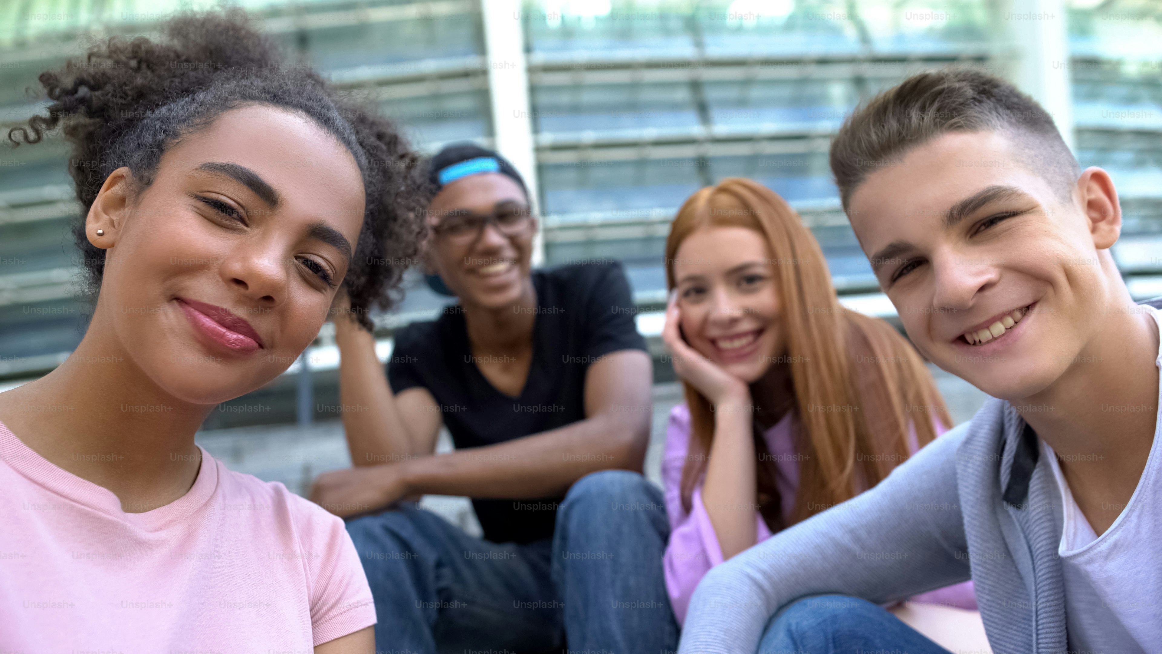 Fröhliche multiethnische Teenie-Freunde, die vor der Kamera lächeln, gemeinsame Freizeit