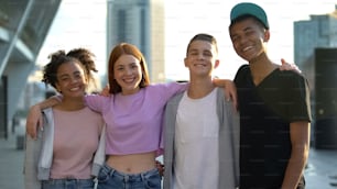 Cheerful multi-racial friends hugging smiling camera, teenage togetherness