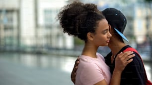 Teen couple of teenagers hugging during outdoor date, love connection affection