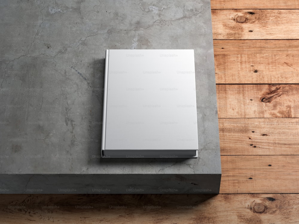 Maquete Livro Branco com capa dura texturizada sobre piso de concreto. Renderização 3D