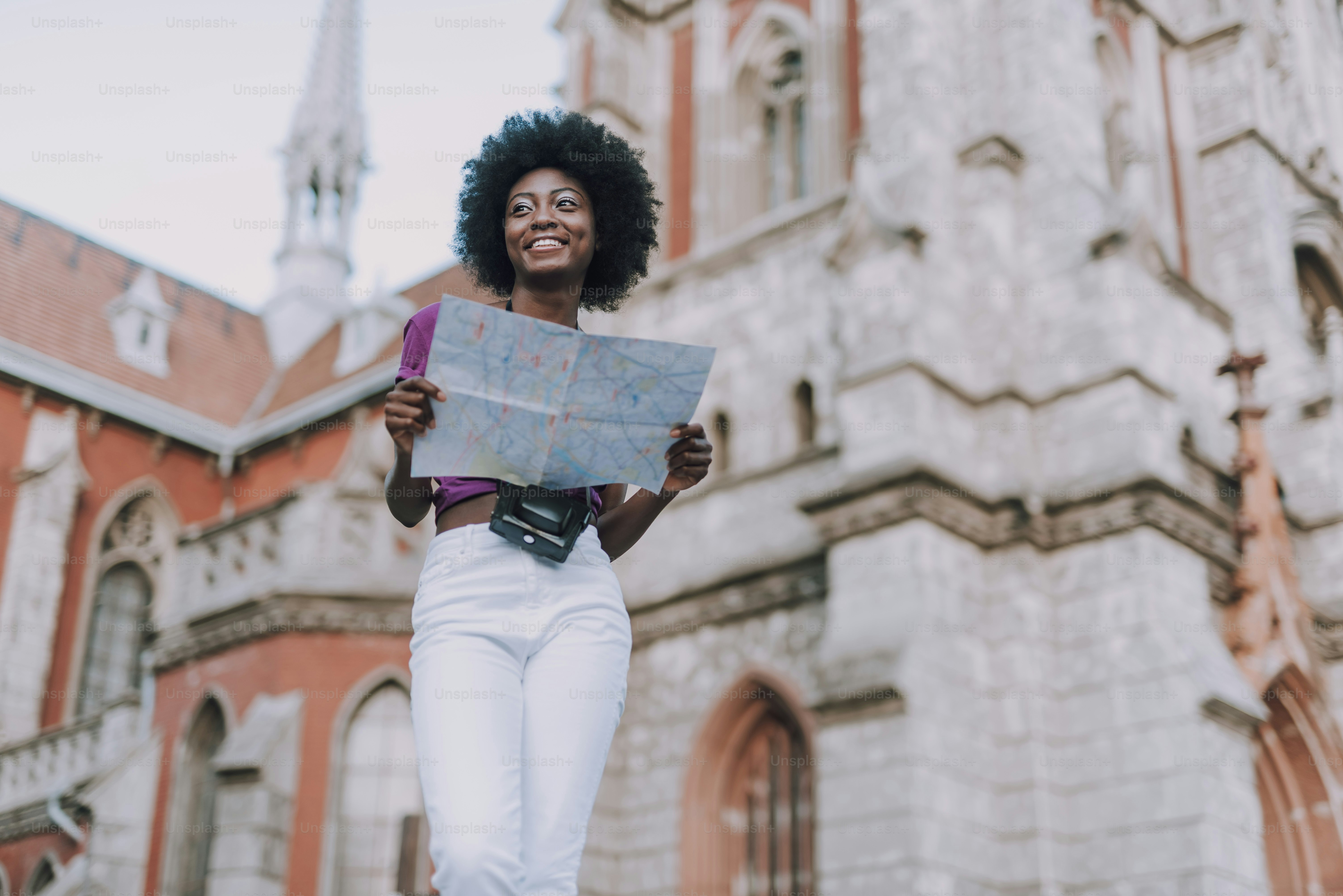 Pretty lady walking with map in the city