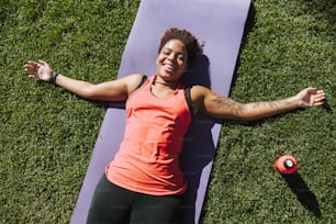 Smiling young woman resting on the grass stock photo