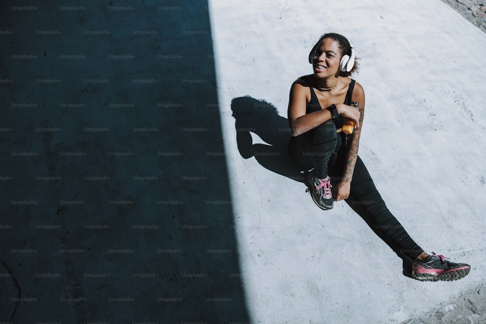 Smiling young woman listening to music and holding bottle of juice stock photo. Website banner