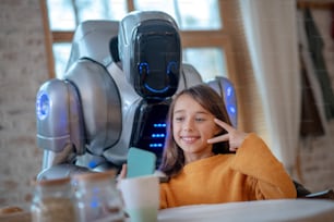 Selfie. Smiling girl in orange shirt smiling nicely while making selfie with robot
