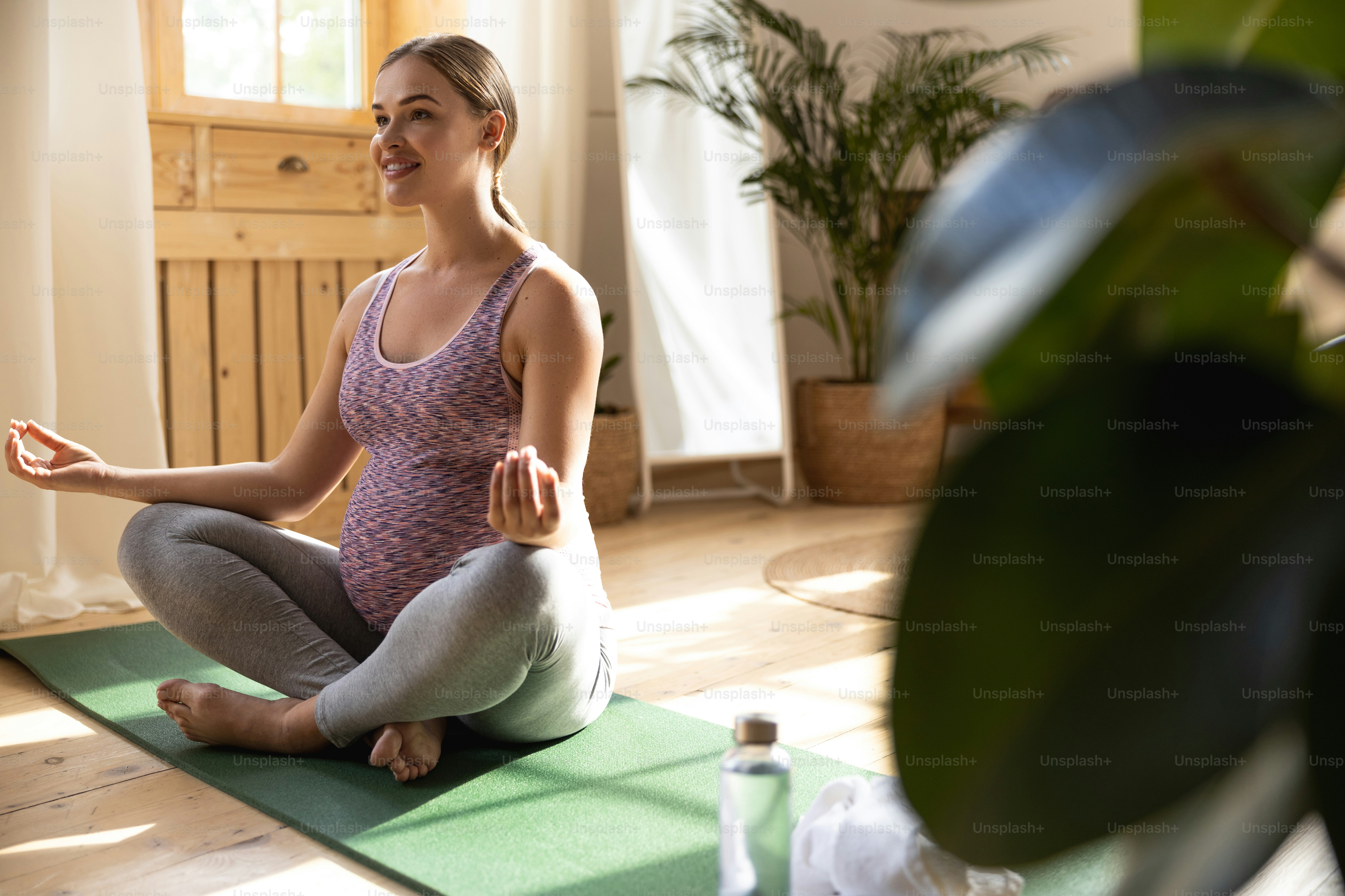 Happy young expectant mother resting after after exercises stock photo