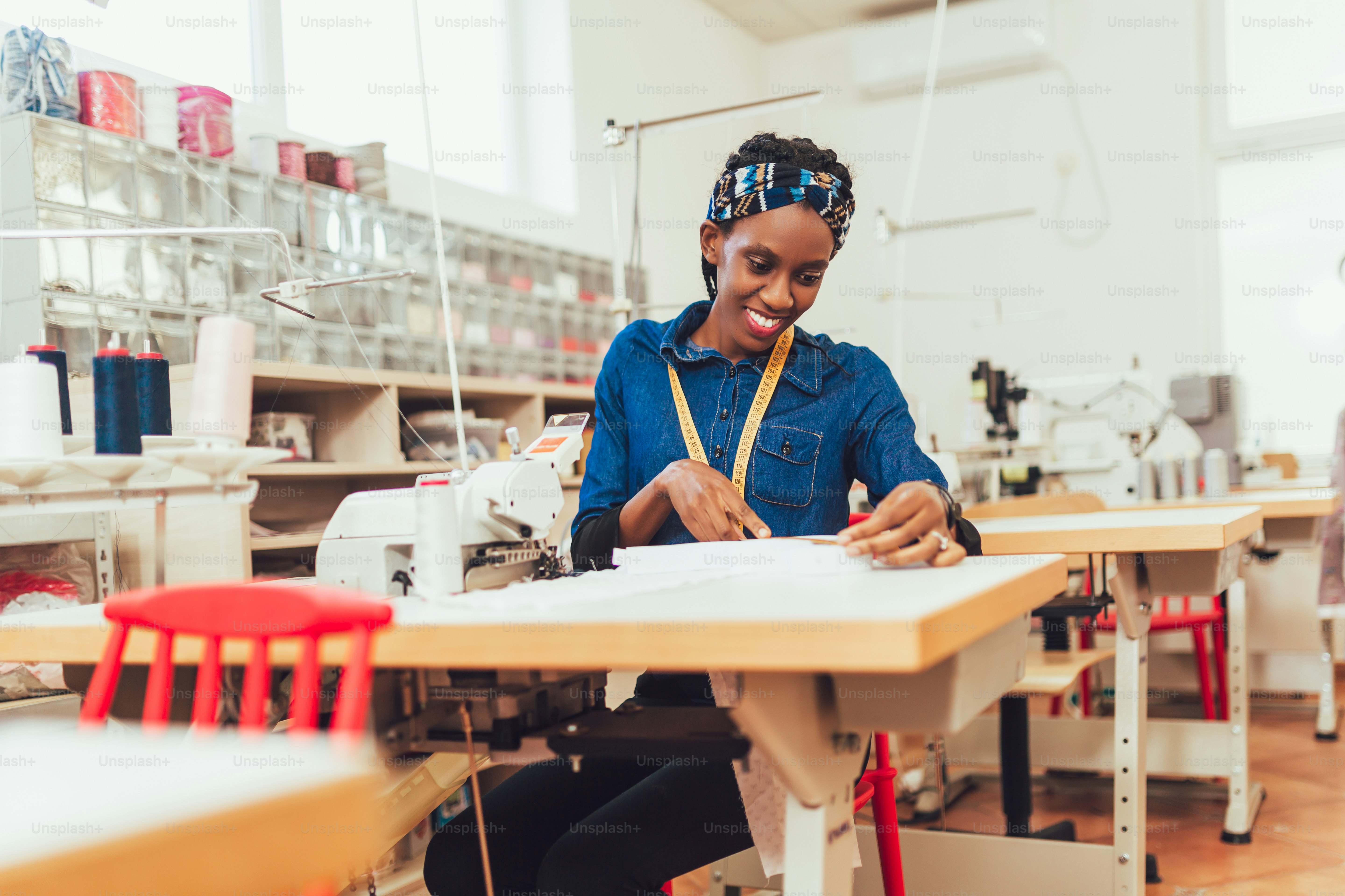 Young african textile worker sewing on production line. Dressmaker ...