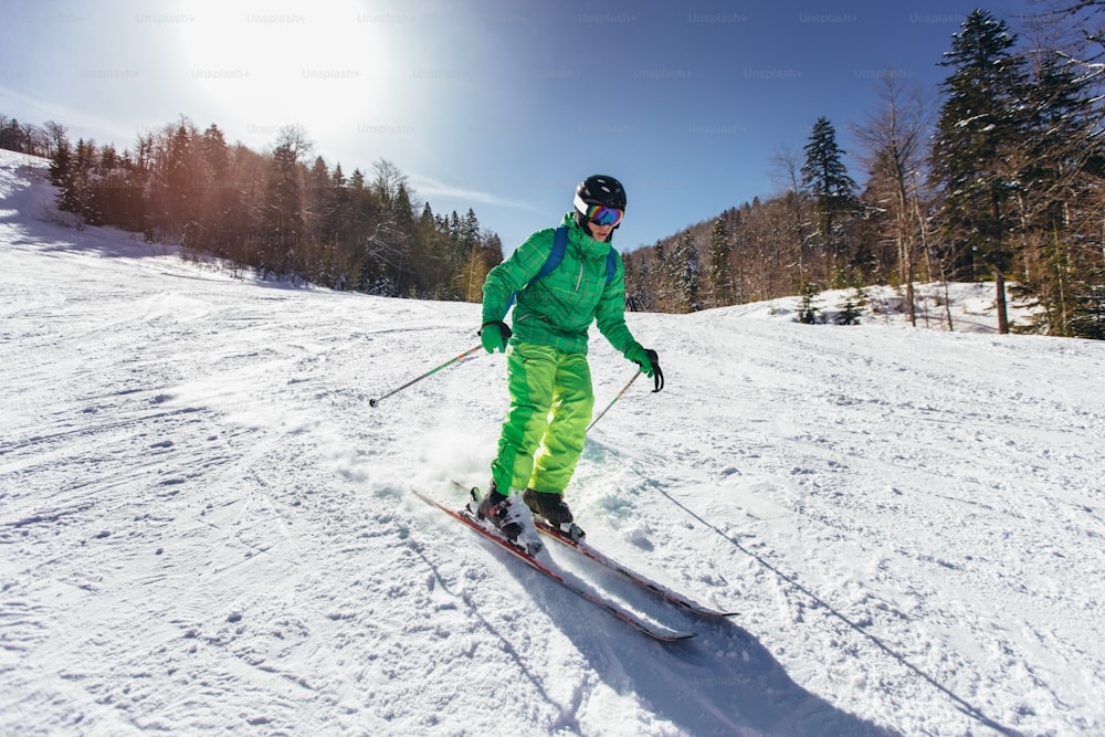 Junger Athlet Freestyle Skifahrer hat Spaß beim Laufen bergab in wunderschöner Landschaft an einem sonnigen Tag während der Wintersaison