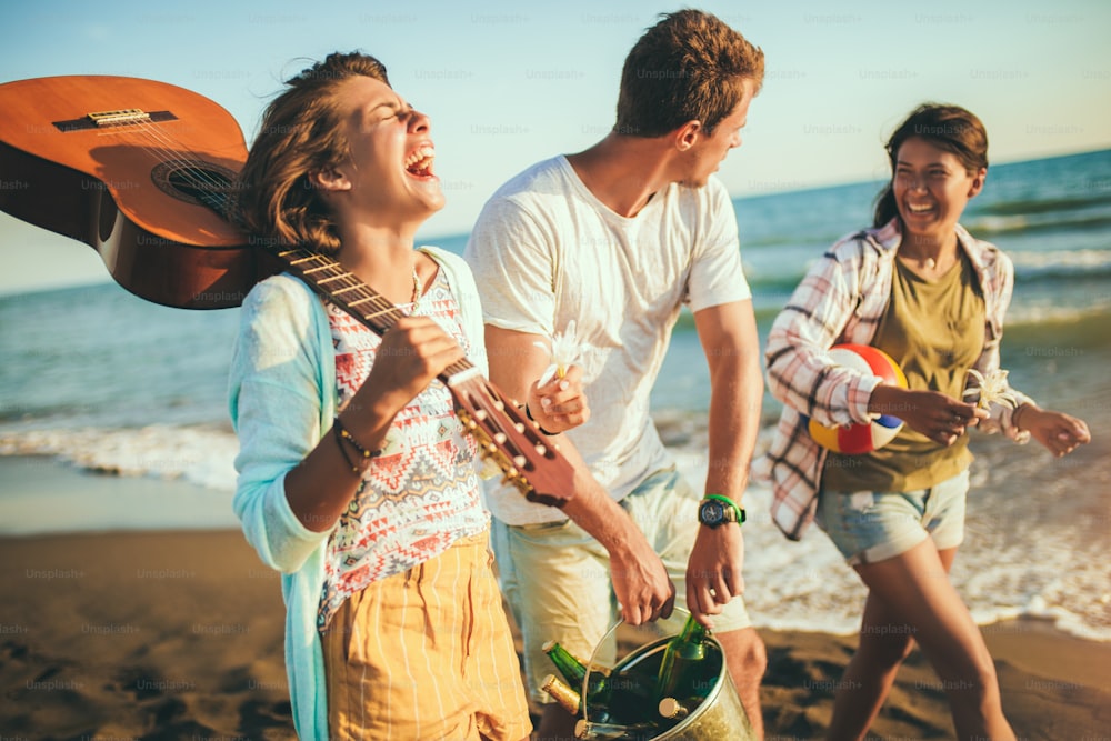Junge Leute, die glücklich im Urlaub sind. Sie gehen auf die Strandparty.