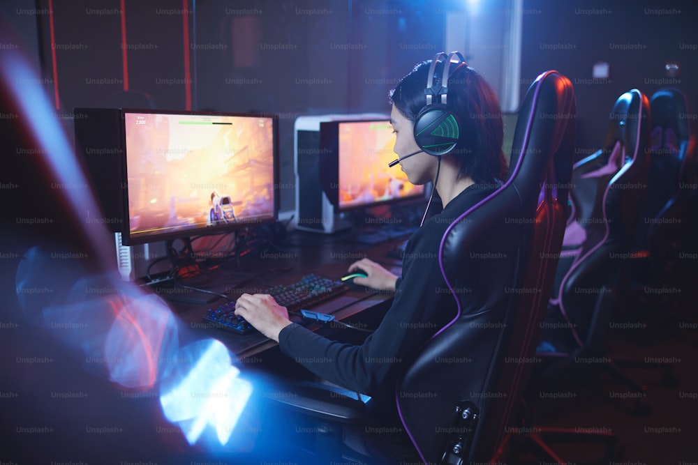 Retrato de vista trasera de un hombre asiático jugando un tirador de videojuegos en un estudio de deportes cibernéticos, espacio de copia