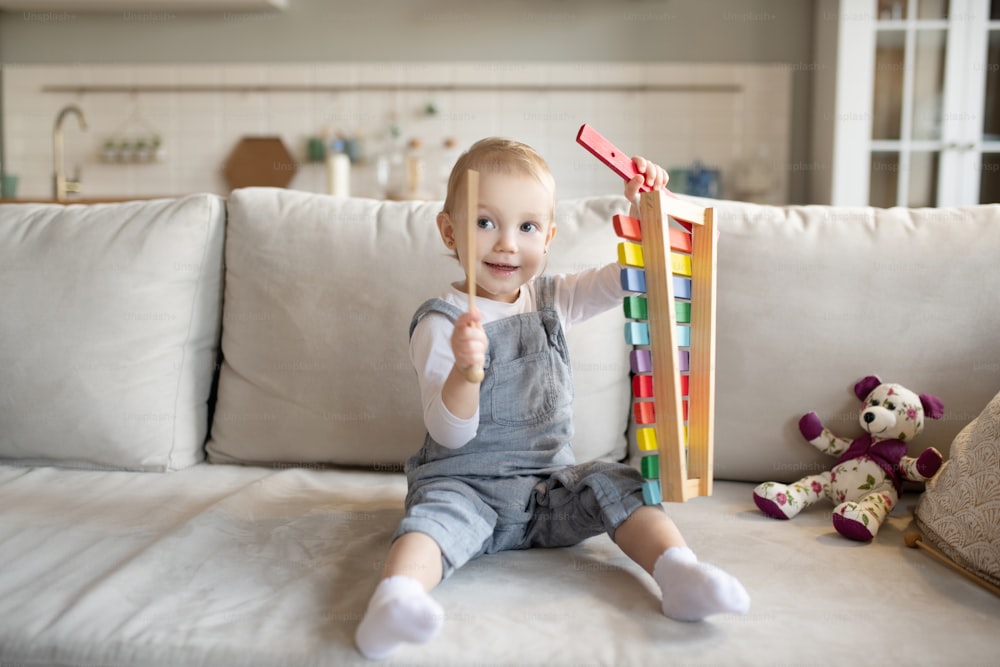 Happy kid. Pretty little baby girl playing with xylophone