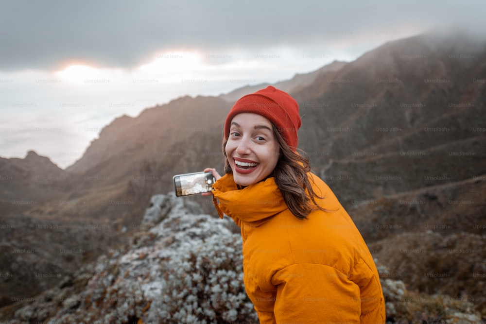 Ritratto di un giovane viaggiatore vestito con giacca e cappello luminosi che si gode un viaggio in montagna, viaggiando sull'isola di Tenerife, Spagna