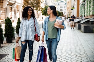 Chicas jóvenes sosteniendo bolsas de compras en la ciudad. Concepto de compra