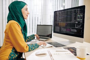 Female software developer implementing programming code she is working on laptop