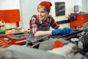 Cute female mechanic holding a spanner in her hands