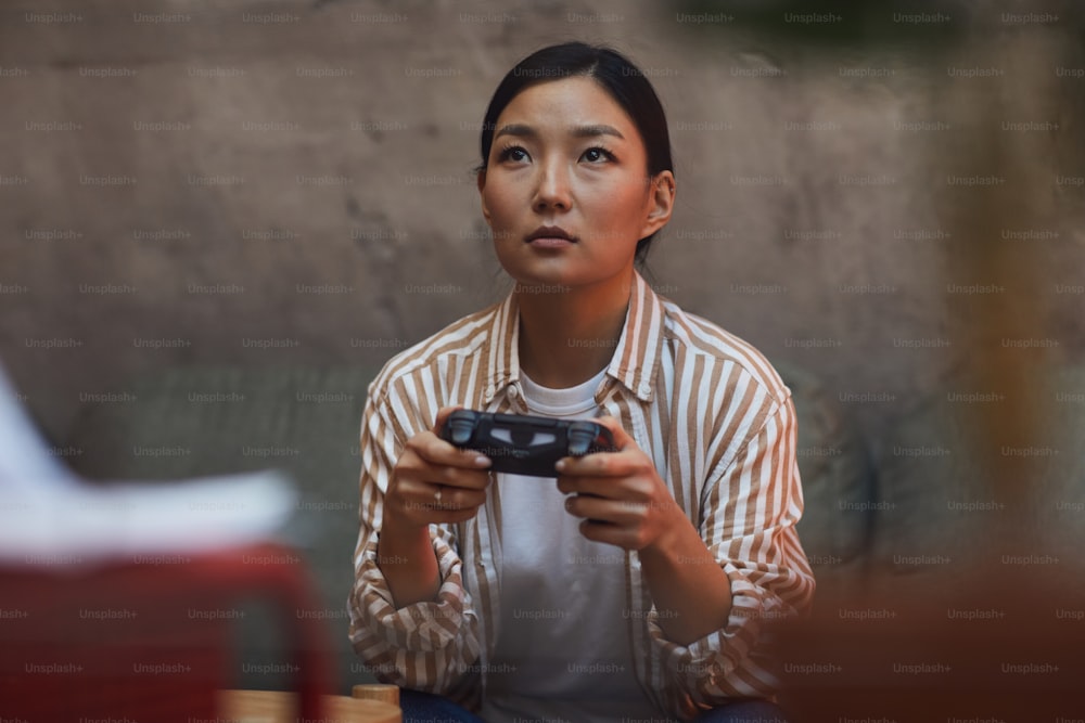 Retrato da jovem mulher asiática jogando videogames via console de jogos, espaço de cópia