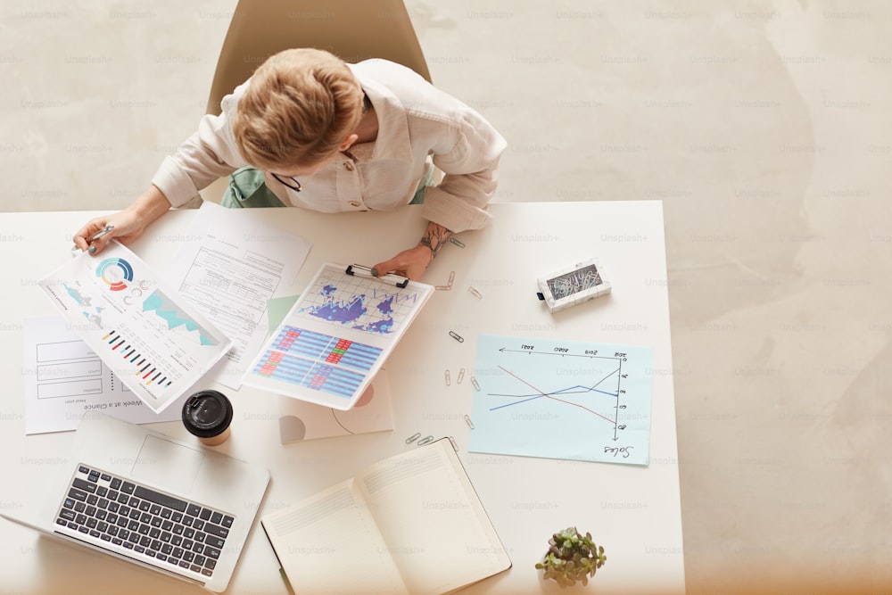 Above view background of modern businesswoman holding data charts while sitting at table, copy space