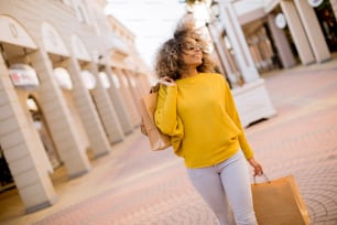 Mujer negra joven y bonita con cabello rizado en las compras