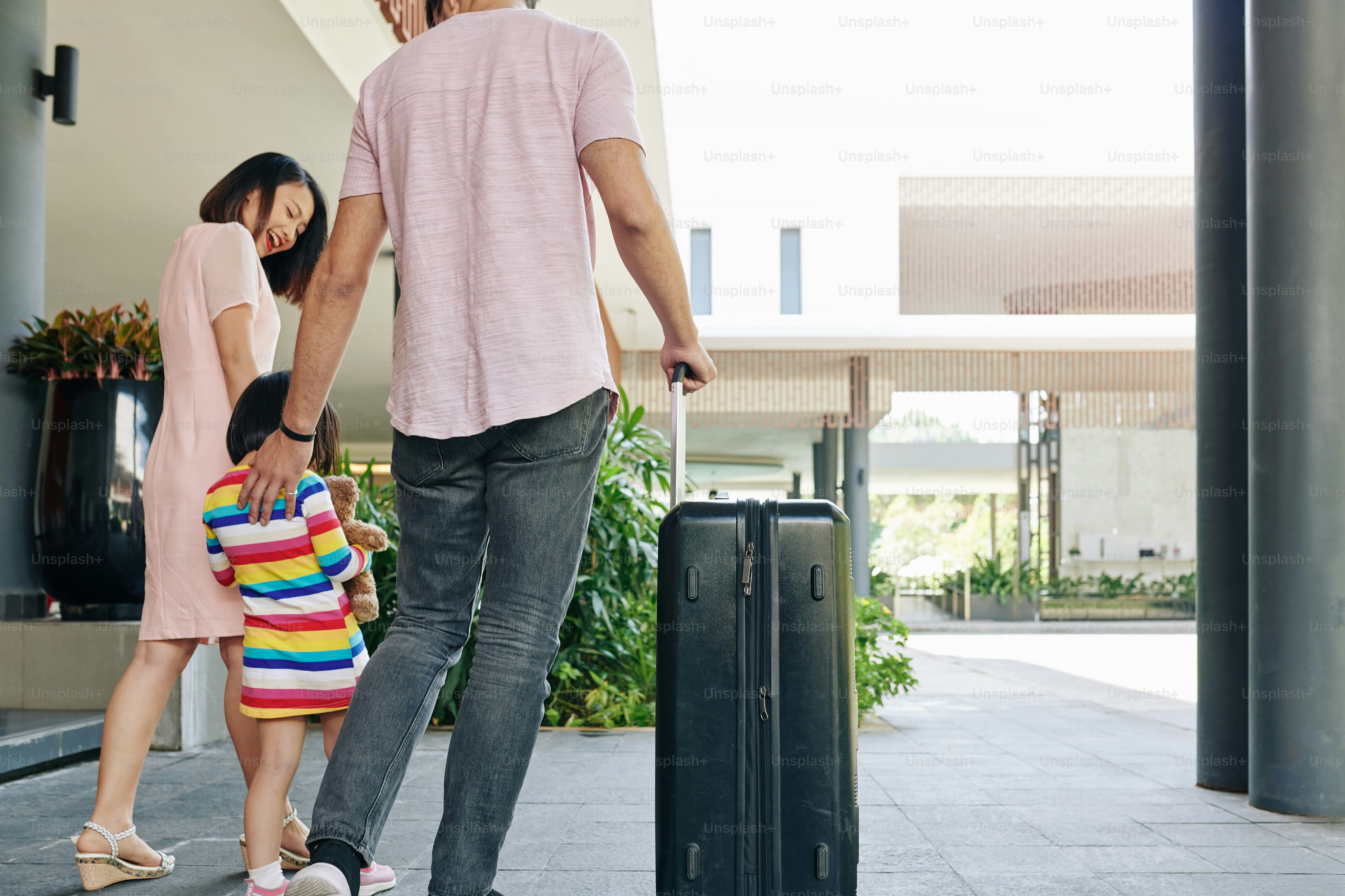 Famiglia asiatica felice con la grande valigia che lascia l'hotel e fter soggiorna per alcuni giorni