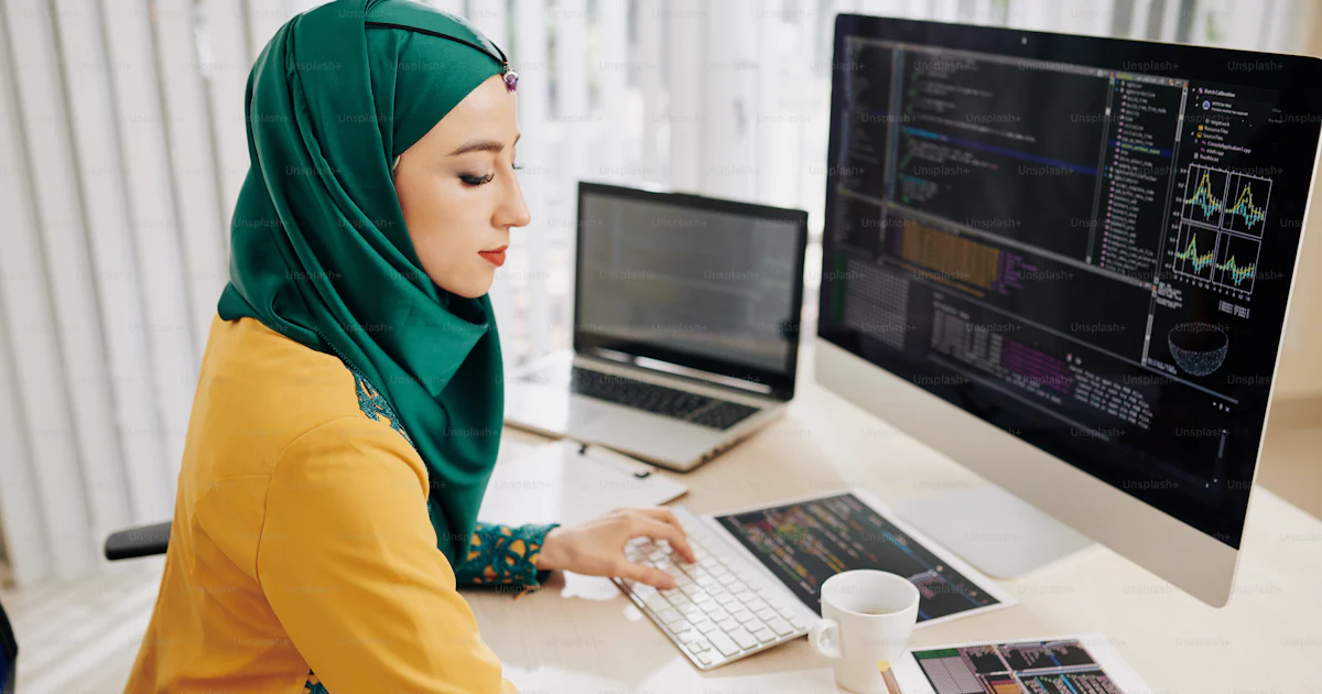 Young muslim female software developer working on programming code and ...